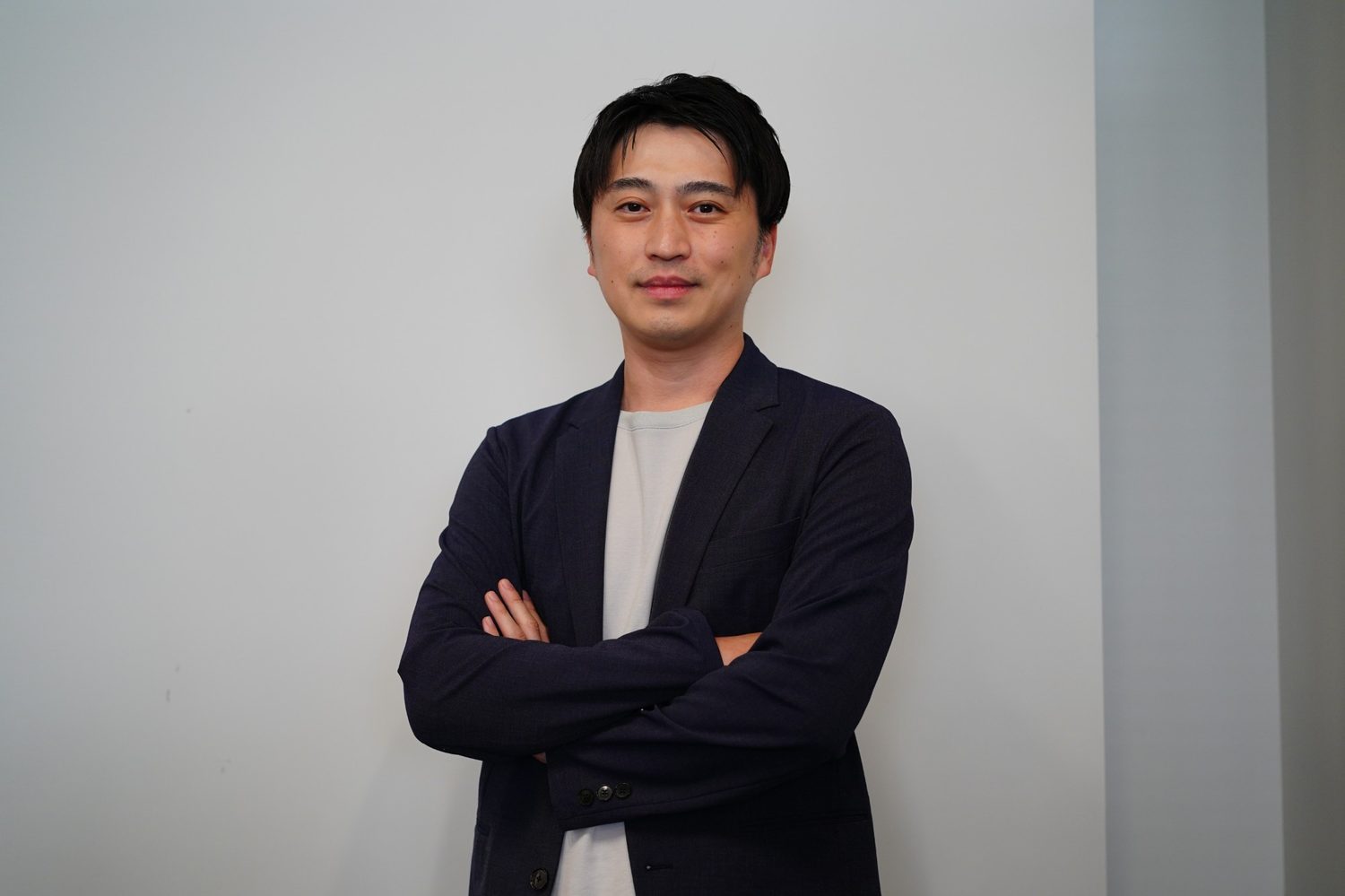 腕を組んで立つ代表社員 金村進介